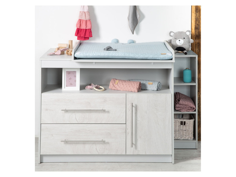 Commode à langer avec deux tiroirs et des étagères ouvertes.