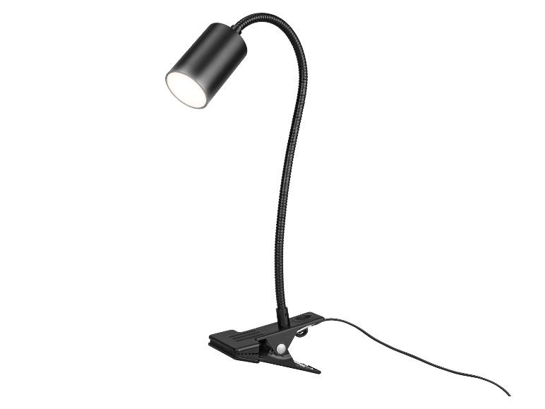 Lampe de bureau noire avec pince et bras flexible, émettant une lumière vive.