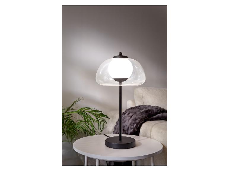 Lampe de table moderne avec abat-jour en verre et base noire.