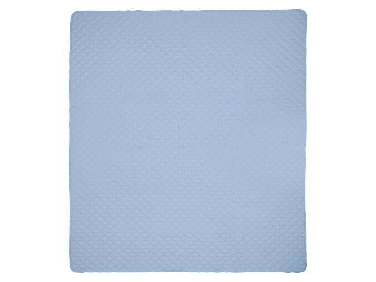 Couverture matelassée bleu clair avec un motif en écailles.