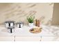 Ensemble de casseroles en acier inoxydable avec couvercles en verre sur un comptoir de cuisine.