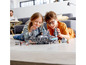 Deux enfants jouent avec un modèle LEGO Star Wars Millennium Falcon.