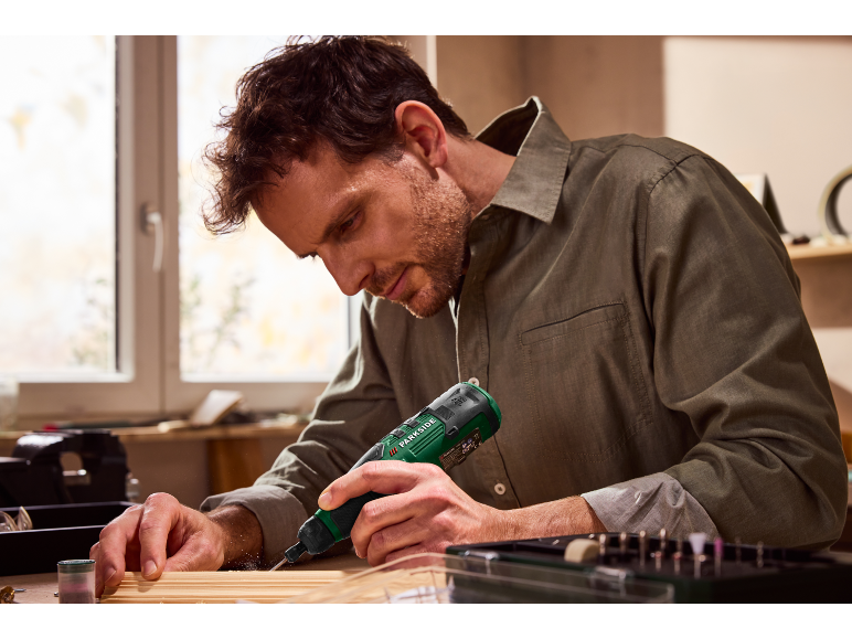 Homme utilisant un outil rotatif Parkside pour le travail du bois.