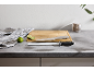 Comptoir de cuisine avec planche à découper, couteau, fusil à aiguiser, citrons verts et torchon.