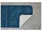 Un tapis de bain bleu foncé avec un revêtement antidérapant blanc.