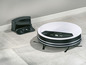 Un aspirateur robot Silvercrest blanc avec sa station de charge.