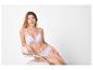 Femme en soutien-gorge et culotte blancs assise sur une chaise