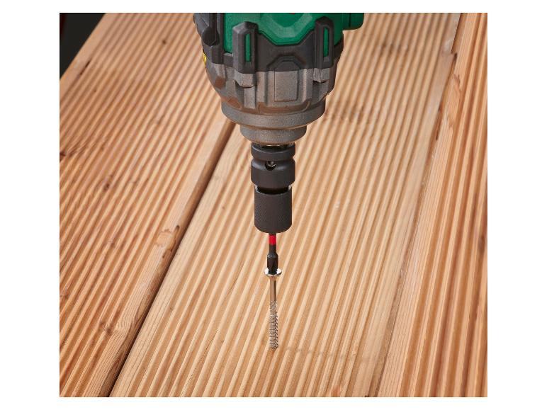 Perceuse vissant une vis dans une planche en bois.