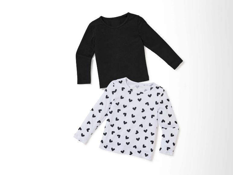 Deux t-shirts à manches longues, un noir et un blanc avec des cœurs noirs.