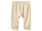 Pantalon de bébé beige clair avec taille élastique et poignets côtelés.