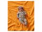 Bébé en grenouillère tricotée à capuche, allongé sur une couverture orange.