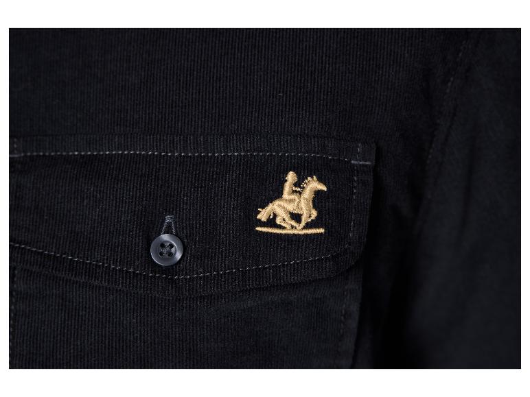 Gros plan sur une veste en velours côtelé noir avec un cavalier brodé sur un cheval.