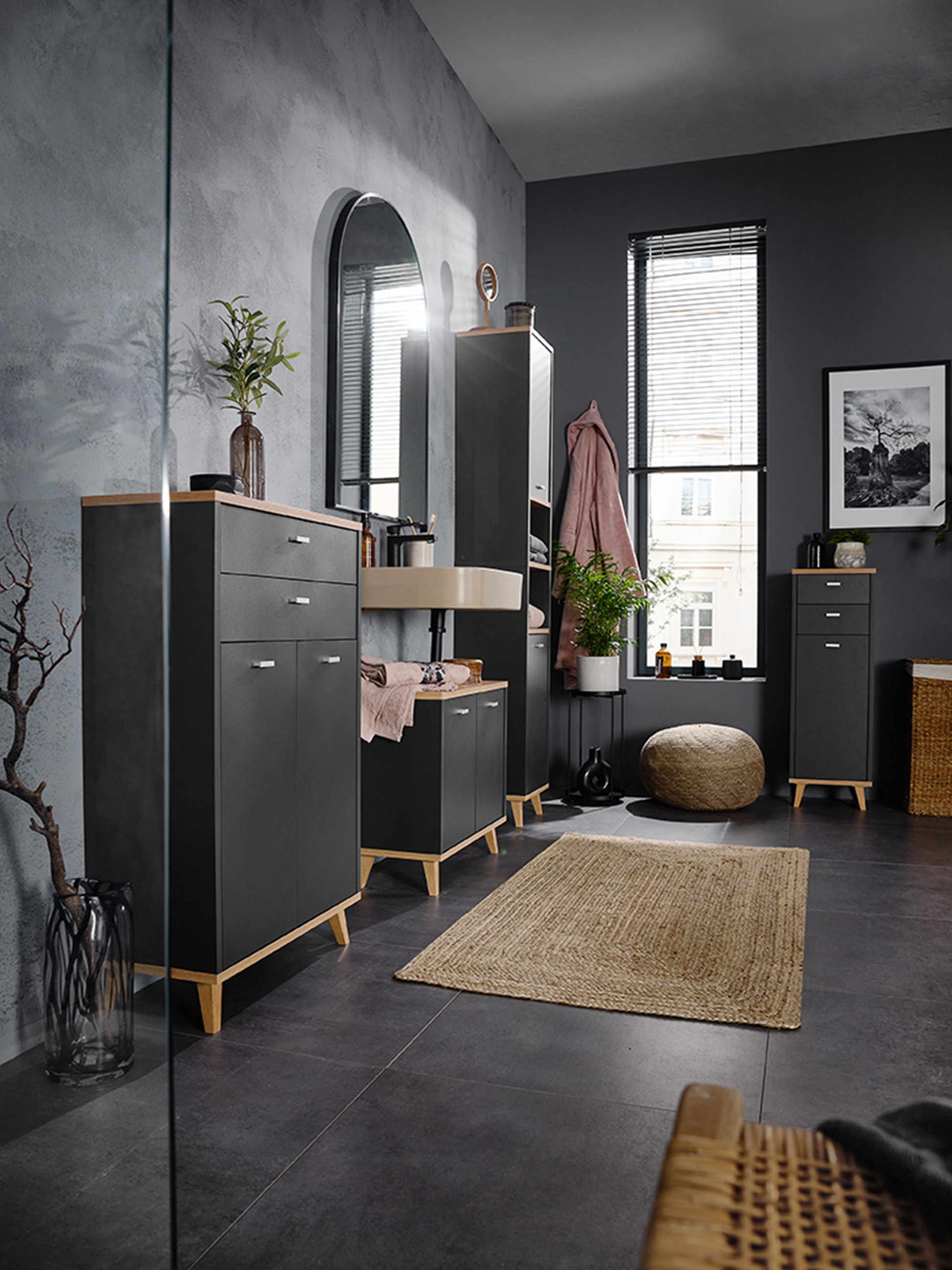 Salle de bain avec des armoires gris foncé, des détails en bois et un lavabo mural.