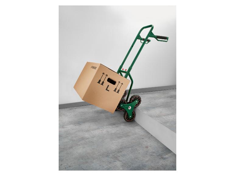 Diable vert avec carton Parkside montant une marche.