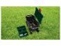 Chariot de jardin avec outils et boîte de rangement sur herbe verte.