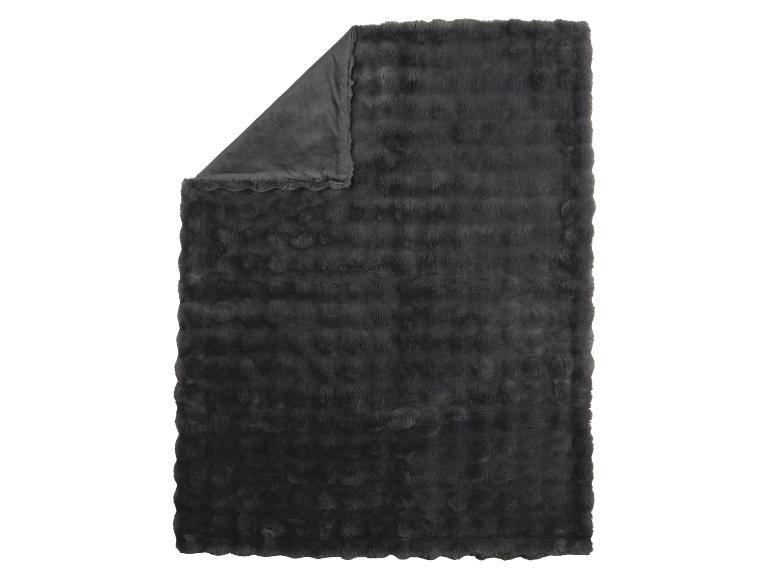 Couverture gris foncé et moelleuse avec un coin plié révélant le dessous lisse.