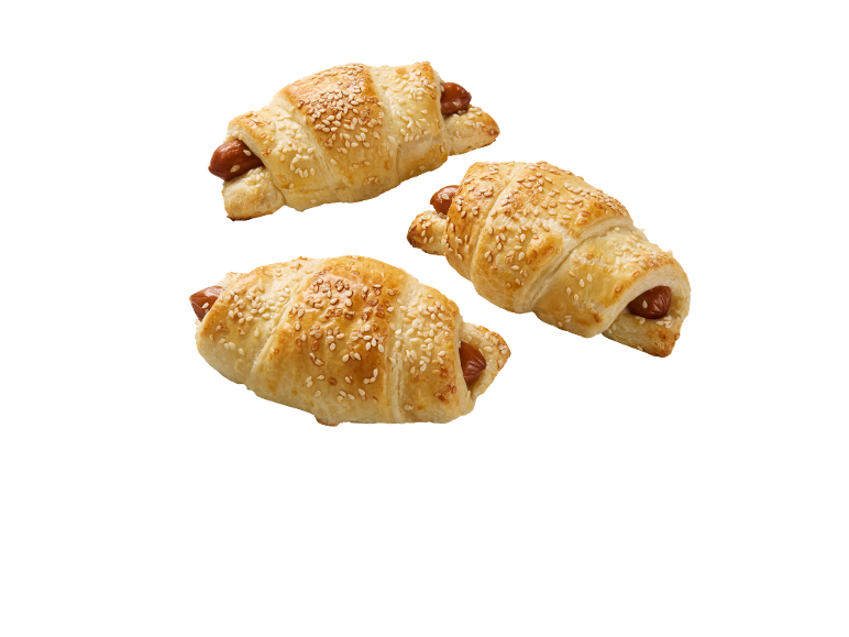 Trois croissants salés avec saucisse et graines de sésame sur fond noir.