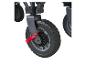 Gros plan d'une roue de chariot noire avec un levier de frein rouge