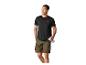 Homme en t-shirt noir et short kaki, tenant une bouteille d'eau.