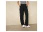 Pantalon noir à jambes larges avec des baskets blanches.