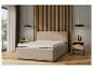 Un lit beige avec un matelas et des tables de chevet.