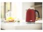 Une bouilloire rouge Russell Hobbs sur un comptoir blanc.