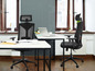 Deux chaises de bureau noires avec appuie-tête dans un bureau.