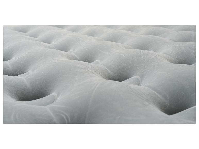 Matelas gonflable gris avec surface ondulée.