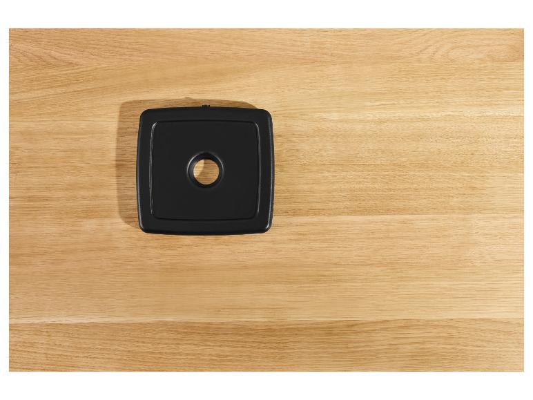 Sous-verre carré noir sur un comptoir en bois.