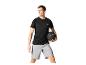 Homme en t-shirt de sport noir et short gris tenant un ballon d'entraînement noir.