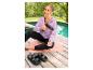 Femme en veste de loisirs lilas CRIVIT assise au bord de la piscine avec un masseur.