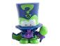 Une petite figurine verte et bleue avec un chapeau.
