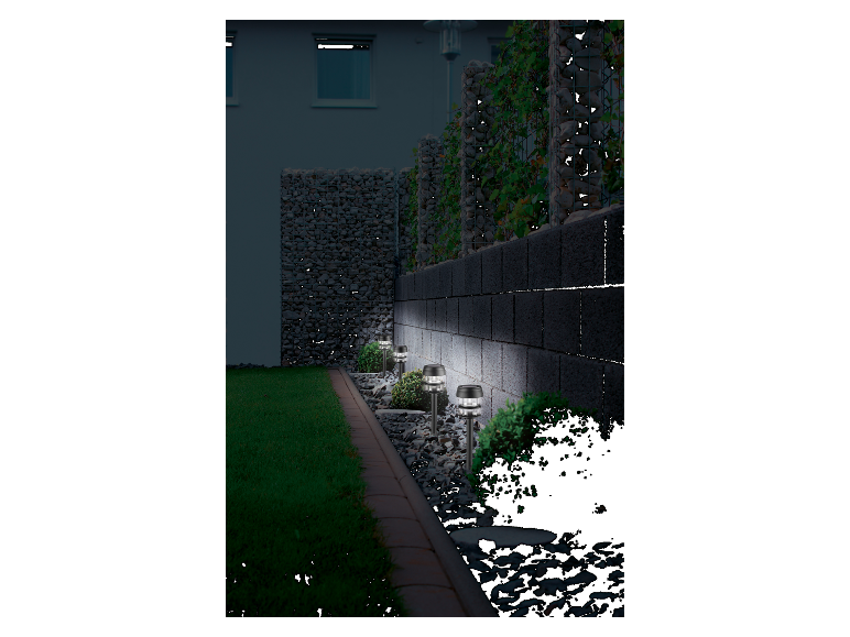 Des lampes solaires éclairent un mur en pierre dans un jardin.