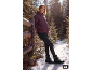 Femme dans une forêt enneigée portant une doudoune prune, un pantalon noir et des bottes.