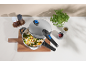 Autocuiseur ouvert avec riz et légumes sur une planche à découper en bois, avec épices.