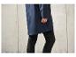 Un imperméable bleu avec un legging noir.