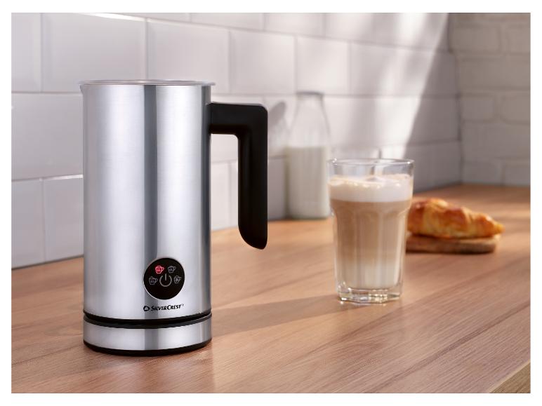 Mousseur à lait SilverCrest sur un comptoir en bois avec un verre de latte et un croissant.