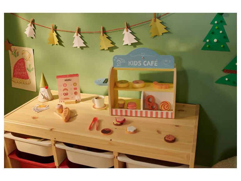 Café de jeu pour enfants avec des jouets en bois, un menu et des décorations de Noël.