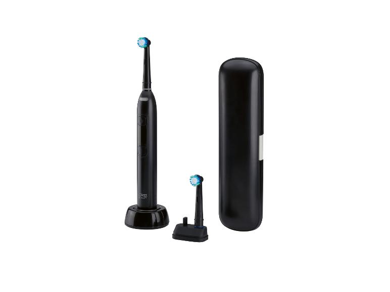 Brosse à dents électrique noire avec station de charge, tête de rechange et étui de voyage.