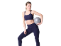 Femme en brassière de sport et legging bleu foncé tenant un petit ballon d'exercice.