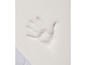 Une empreinte de main sur un matelas en mousse blanche.