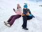 Deux enfants en vêtements d'hiver jouent dans la neige.