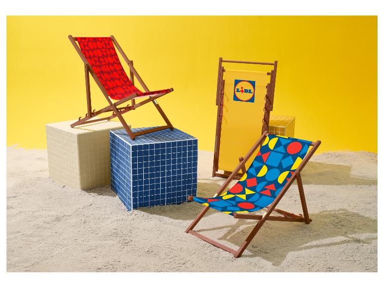 Trois chaises de plage aux motifs géométriques et une avec logo, sur le sable.
