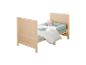 Lit bébé en bois clair avec literie bleue et blanche, oreiller en forme d'étoile.