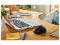 Une souris sans fil, un ordinateur portable et des fournitures de bureau sur un bureau.