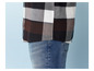 Une partie d'une chemise à carreaux en noir, blanc et marron, et un jean bleu.
