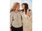 Deux femmes souriantes portent une chemise en mousseline de coton et une jupe en crochet beige.