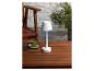 Une lampe blanche avec un abat-jour en forme de lanterne sur une table en bois.