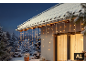 Guirlande lumineuse de Noël LED style stalactites sur une maison enneigée.