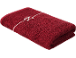 Serviette rouge avec un nœud blanc brodé.